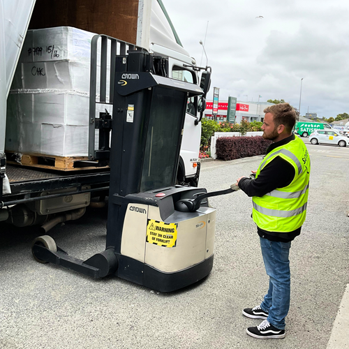Satisfy Food Rescue operations coordinator Cameron Crawley uses the walkie stacker forklift to unload pallets